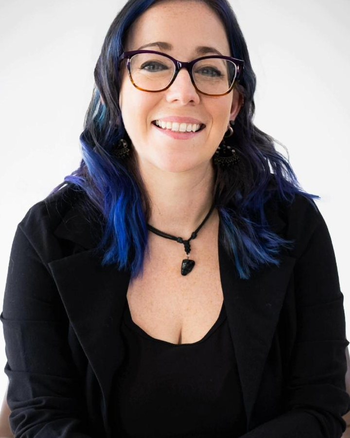 Amanda Manchack, LCSW-S, smiling, seated in a leather chair