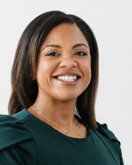 Monique Griffin, PMHNP-BC, smiling, in a green top
